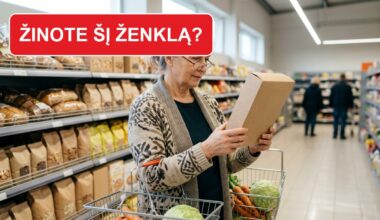 Moteris parduotuvėje atidžiai skaito pakuotės etiketę
